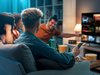 group of young adult friends sitting on a couch watching TV together