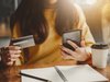 woman holding a credit card and a mobile phone