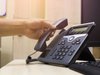 Close up on hand holding phone at office desk