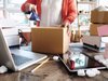 person taping up a box to ship